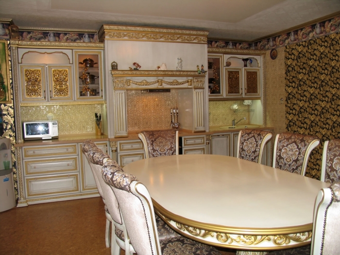 Кухонный гарнитур, обеденная зона, буфет выполнены в одном тематическом ключе. Массив ясеня, белая эмаль, золотая патина.
