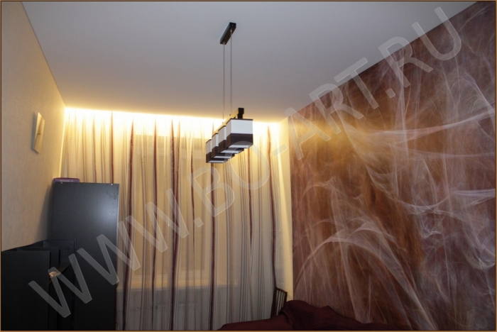 Фото натяжного потолка торговой марки Descor (Дескор) в спальне. Конструкция натяжного потолка выполнена с "карманом" для штор, в котором установлена светодиодная регулируемая (диммируемая) подсветка.