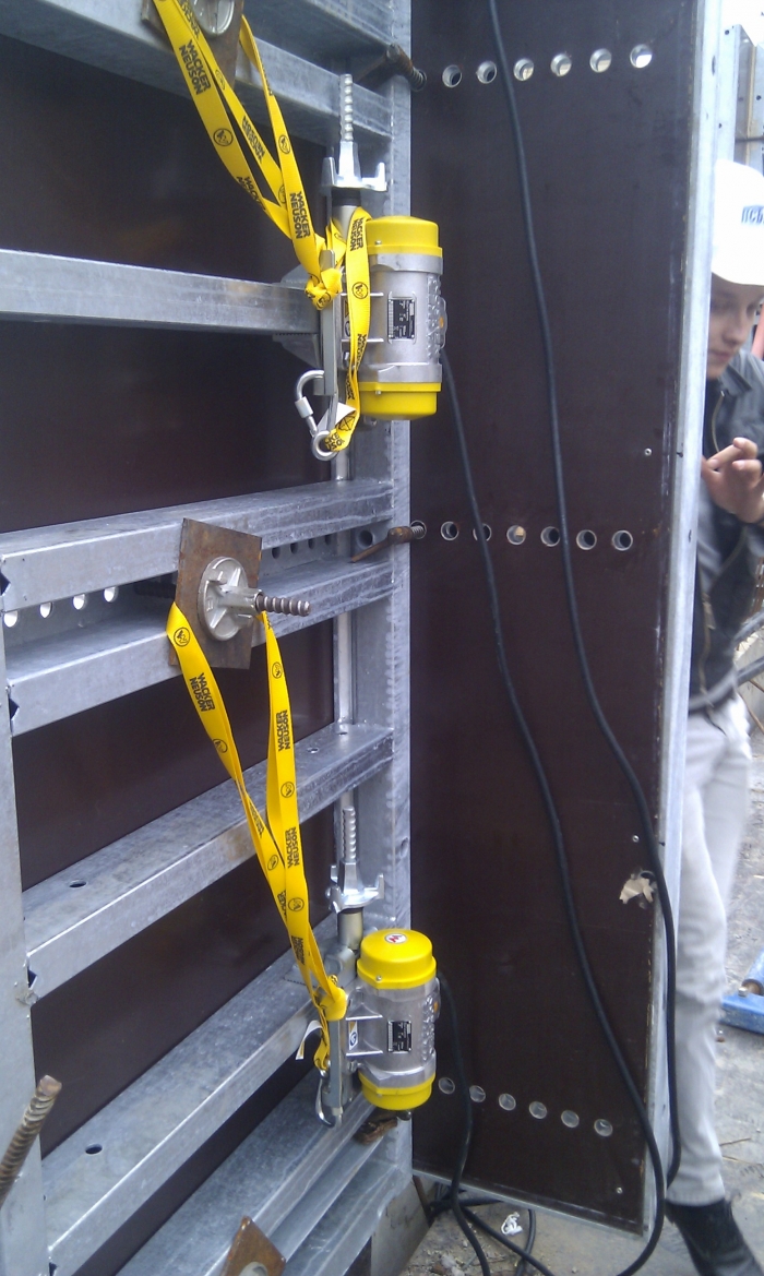 Установка внешних вибраторов на опалубку при заливке несущих  колонн.