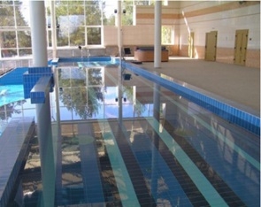 Плавательный бассейн в помещении со сплошным остеклением